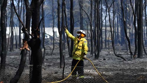 A NSW Rural Fire Service firefighter mops up after a bushfire in the suburb of Llandilo on November 12, 2019 in Sydney, Australia. More than 50 fires are burning across NSW with 200 homes and sheds destroyed and three people confirmed dead. Catastrophic f