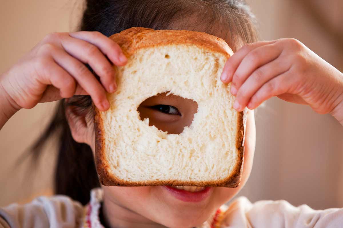 Child holding homemade bread made with a bread maker borrowed from an Australian library