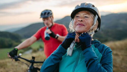 Family riding bicycles together on a scenic rail trail, showing how cycling can help Australians save money, stay fit and enjoy time together.