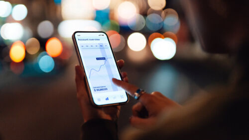 Investor reviewing stock market charts on phone