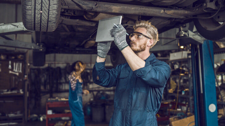 Two mechanics working together in a workshop highlighting teamwork and trades jobs