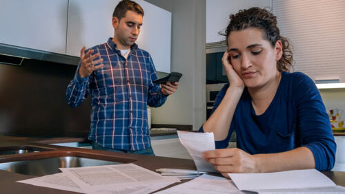 Couple reviewing bank statements and financial documents while discussing separation