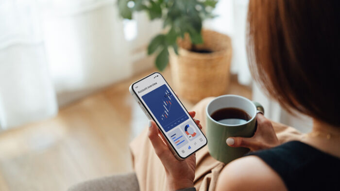 woman reviewing her investment portfolio on smartphone, focused and thoughtful expression