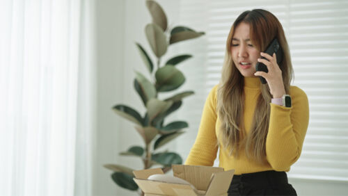 Consumer reviewing bills and emails while lodging a complaint about a bank, insurer or service provider