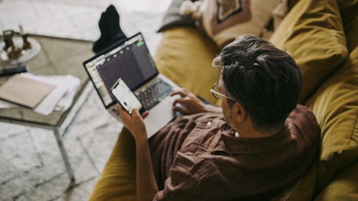 Investor checking sharemarket news and social media updates on a smartphone as markets react to headlines and investor sentiment.