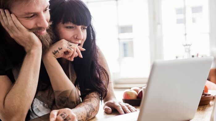 Young Australian couple discussing financial goals and super investment decisions at home.