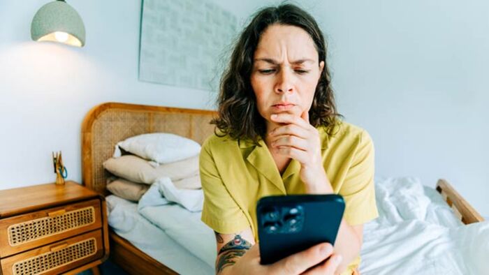 australian woman looks at online banking app after accidentally transferring money to the wrong bank account