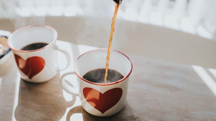 pouring coffee into two mugs to symbolise topping up a loved one's super balance