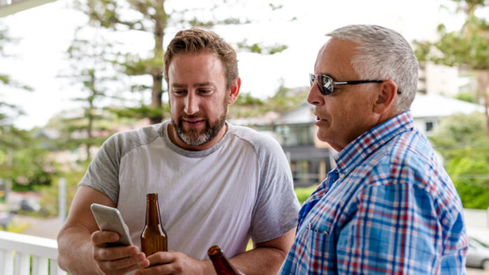 australian man and his father share a beer while discussing inheritance