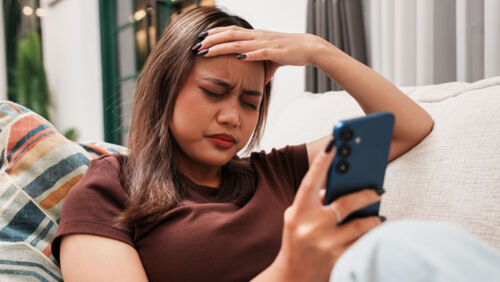 Young woman checking stock market information on her smartphone.