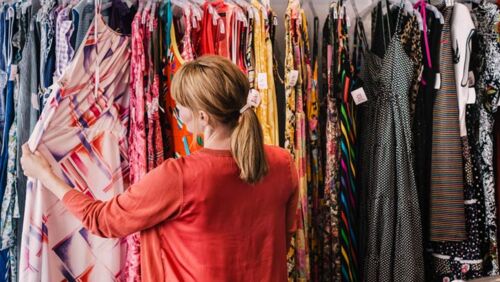 a woman browses a rack of dresses at an op shop ahead of world op shop day on october 17