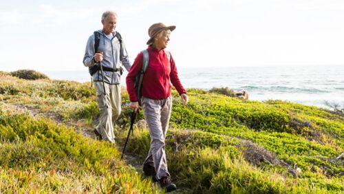 Active senior walking along a scenic coastal path with ocean views, symbolising confidence, independence and a long retirement journey.