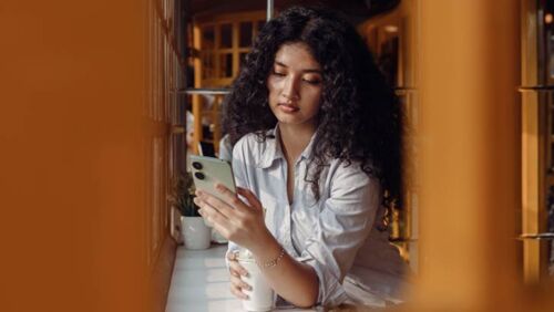 Woman checking savings account interest rates on a smartphone